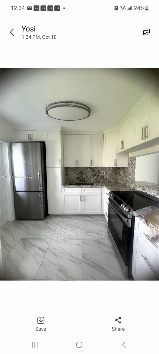 A kitchen features white cabinets, granite countertops, stainless steel appliances, and light marble-patterned tile flooring — 2300 Park Ln # 211, Hollywood FL 33021, HOLLYWOOD, FL