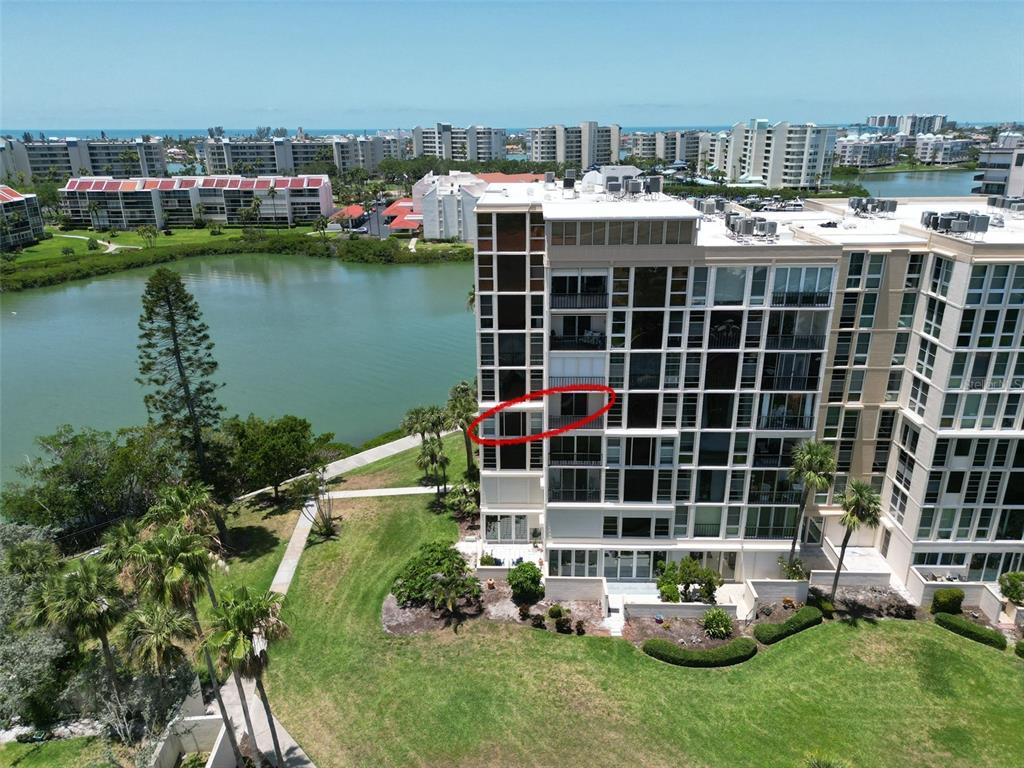 An aerial view of a multi-story apartment building with a red circle highlighting a balcony — 7400 SUN ISLAND DRIVE S UNIT 501, SOUTH PASADENA, FL