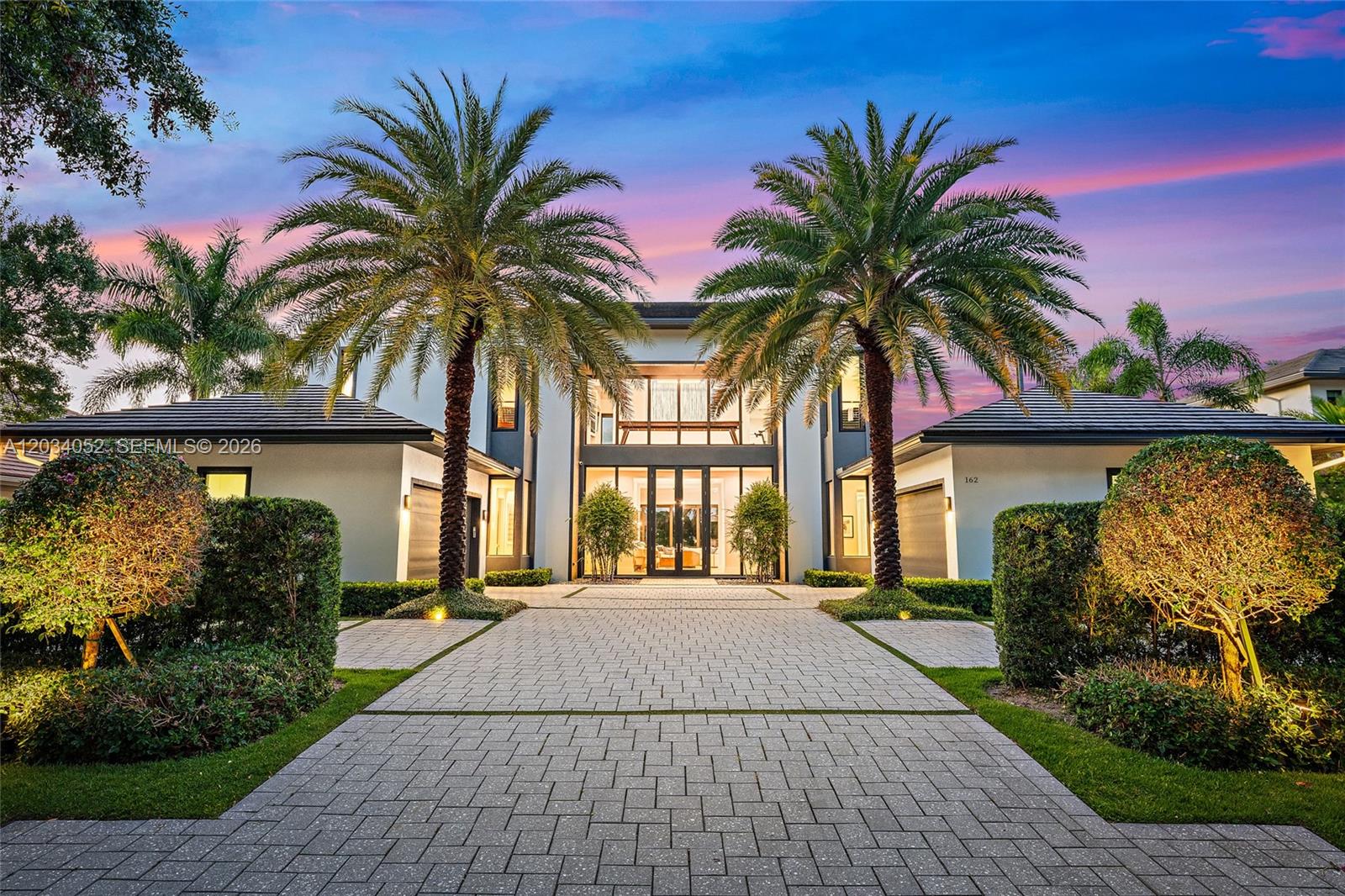 A modern two-story house with a paved driveway and two large palm trees — 162 Commodore Dr, Jupiter FL 33477, JUPITER, FL