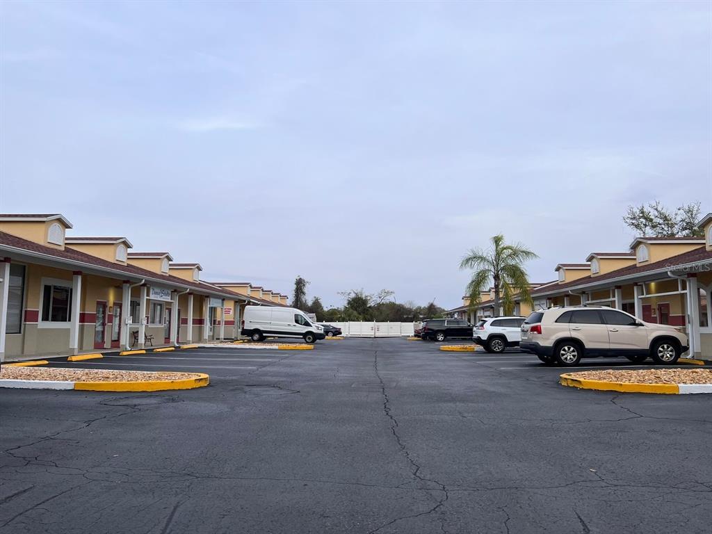 An exterior view of a commercial strip mall parking lot with two rows of buildings — 4400 N HIGHWAY 19A UNIT 9, MOUNT DORA, FL