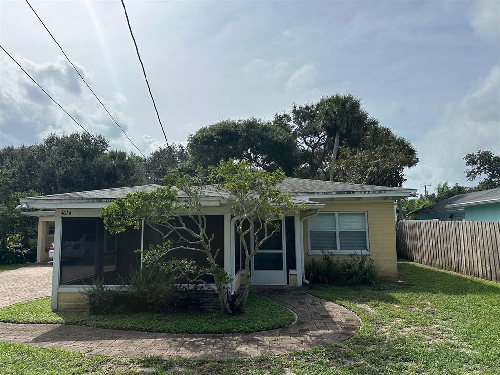 A single-story house with a screened-in porch, yellow brick siding, and a paved walkway — 401 OAKWOOD AVENUE UNIT A, NEW SMYRNA BEACH, FL