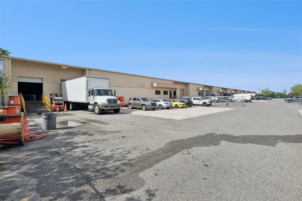 An exterior view of a commercial warehouse building with a loading dock and parking lot — 10235 GENERAL DRIVE UNIT 8, ORLANDO, FL