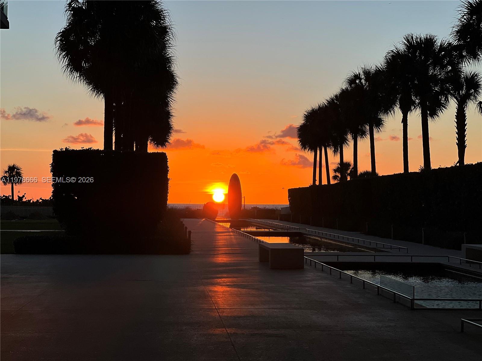 A sunset view over a paved walkway lined with palm trees and reflecting pools — 350 Ocean Dr # 1105N, Key Biscayne FL 33149, KEY BISCAYNE, FL