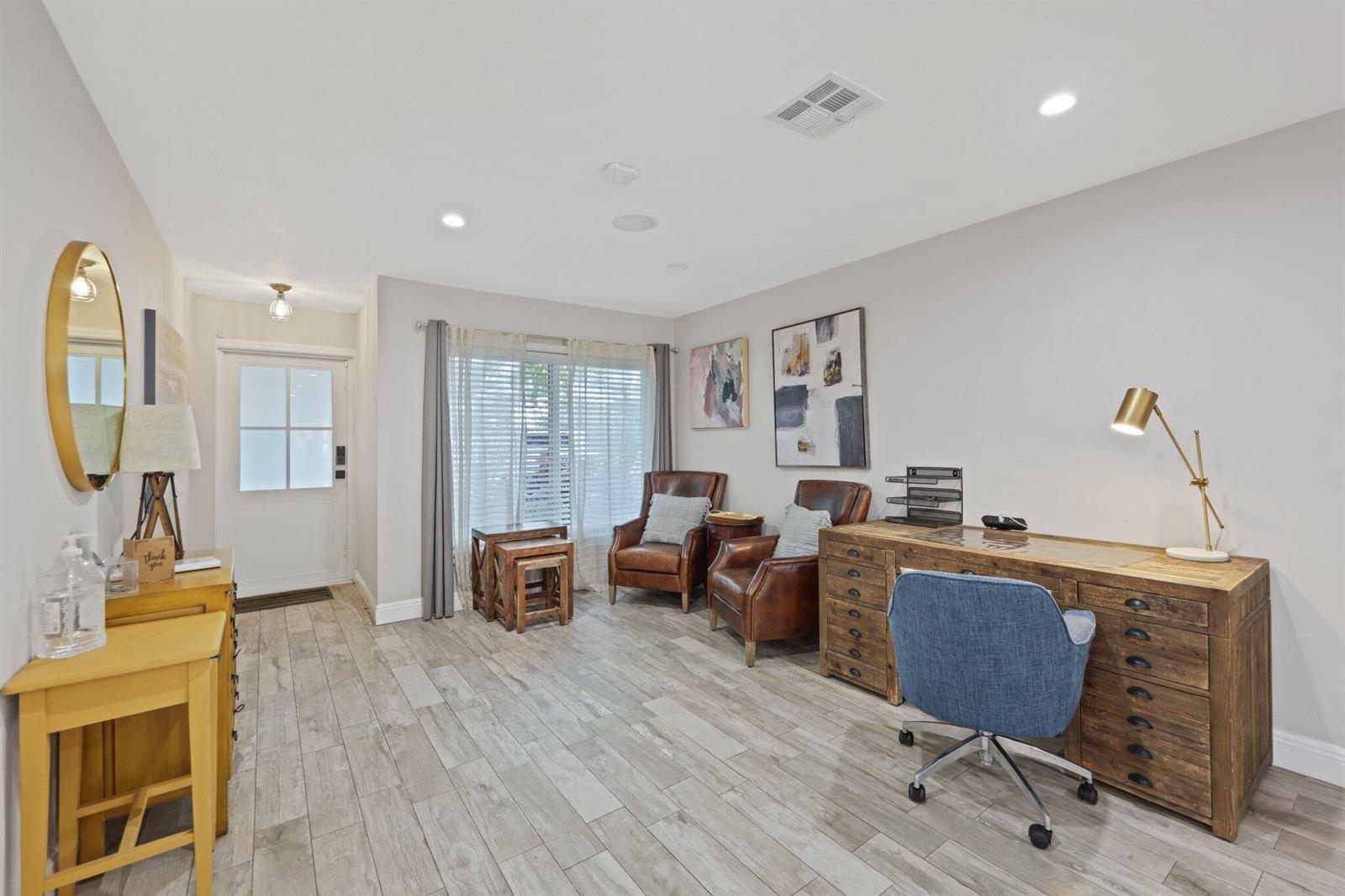 A home office features a wooden desk, two leather armchairs, and light wood-look tile flooring — 513 Curlew Road, Delray Beach FL 33444, DELRAY BEACH, FL