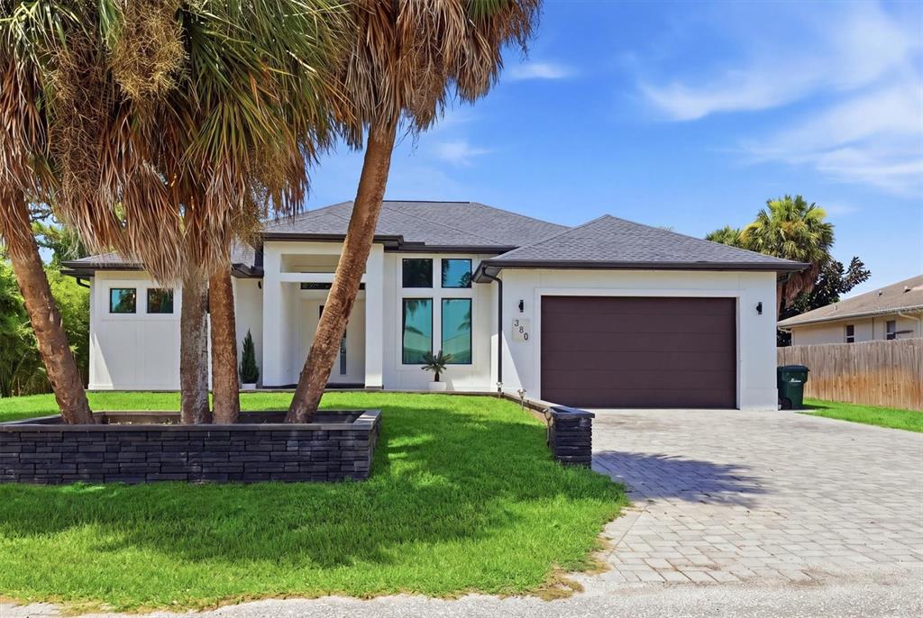 A single-story house with a white exterior, dark roof, and a paved driveway — 380 COWRY ROAD, VENICE, FL