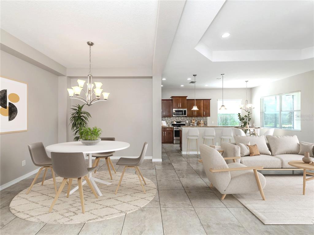 An open-concept dining area and living room with tile floors and a modern kitchen — 11406 BELVEDERE TERRACE, BRADENTON, FL