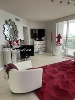 A living room features a white armchair, a red area rug, and a mirrored cabinet — 6301 Collins Ave # 1206, Miami Beach FL 33141, MIAMI BEACH, FL