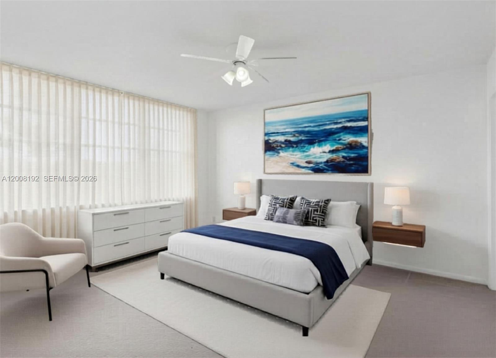 A bedroom features a gray upholstered bed, white dresser, floating nightstands, and coastal wall art — 3300 W Rolling Hills Cir # 606, Davie FL 33328, DAVIE, FL