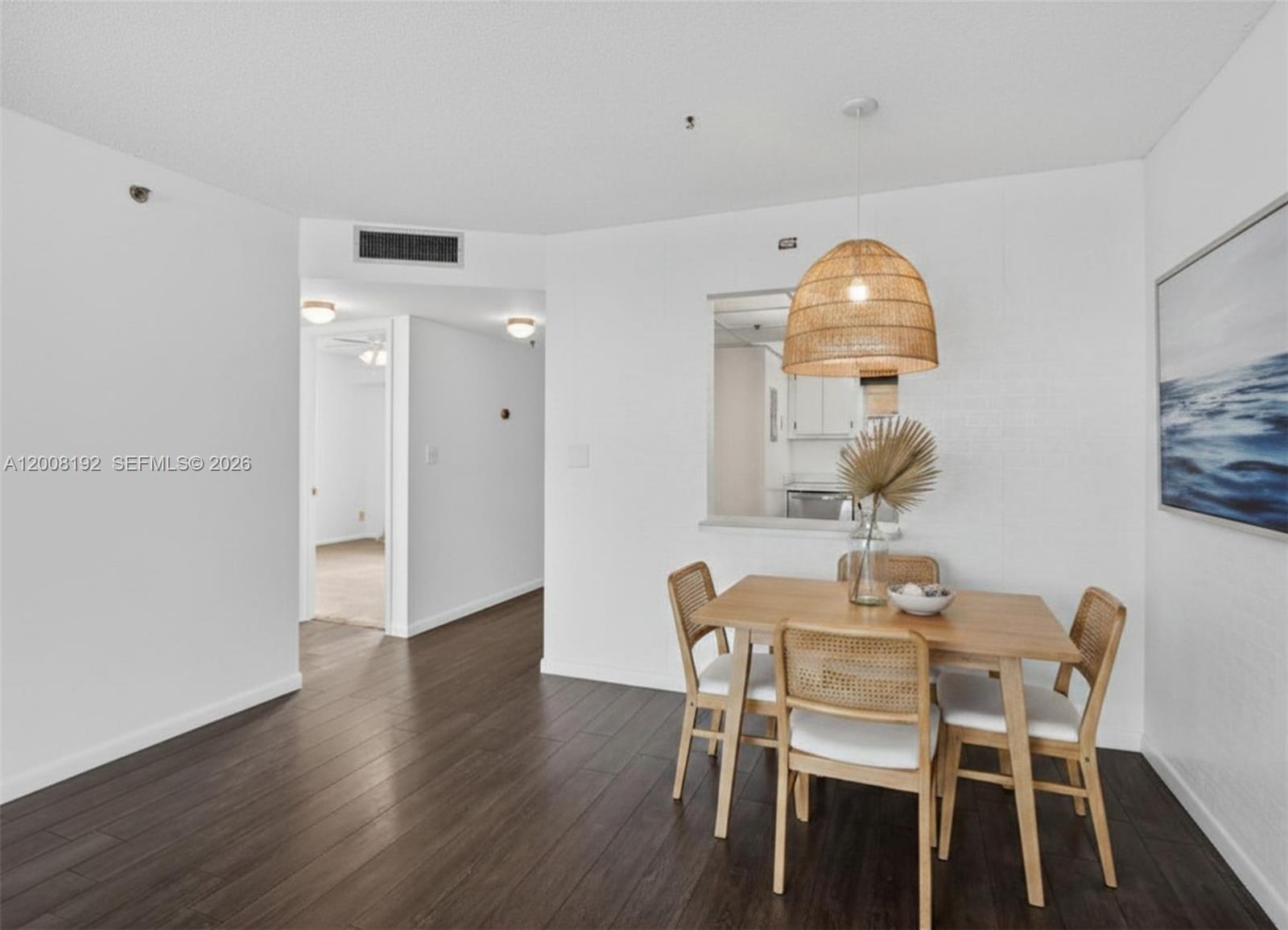A dining area features a wooden table with four cane chairs under a woven pendant light — 3300 W Rolling Hills Cir # 606, Davie FL 33328, DAVIE, FL