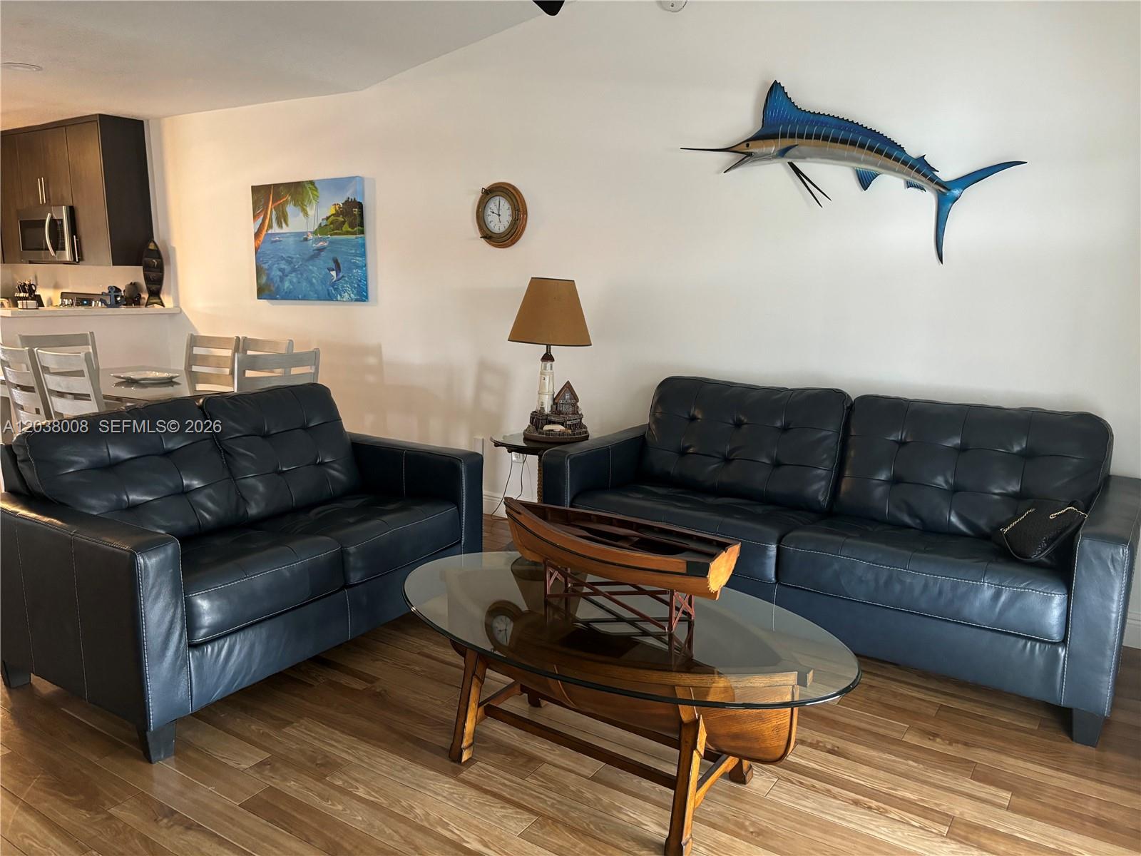 A living room features two dark leather sofas, a boat-shaped coffee table, and nautical decor — 9502 Aviation Blvd # 9502, Marathon FL 33050, MARATHON, FL