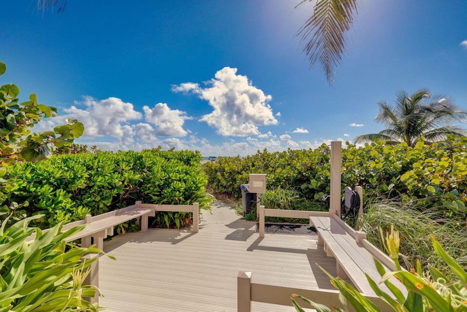 A wooden boardwalk with built-in benches leads through lush green foliage toward the beach — 2800 N Ocean Drive, Riviera Beach FL 33404, RIVIERA BEACH, FL