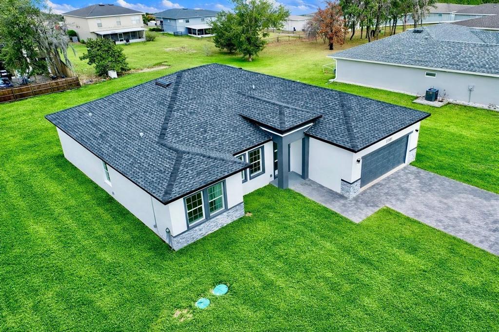 An aerial view of a modern single-story house with a dark shingled roof and lawn — 11591 SW 59TH TERRACE, OCALA, FL