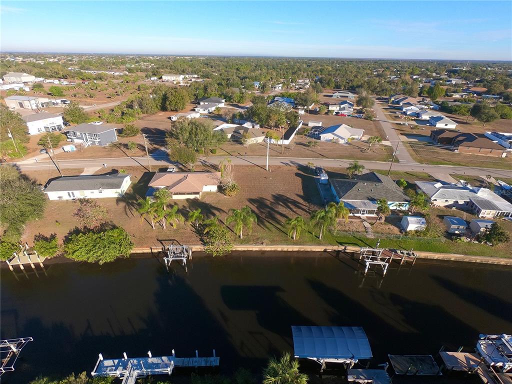 An aerial view shows waterfront houses with private docks along a canal in a neighborhood — 27193 VOYAGEUR DRIVE, PUNTA GORDA, FL