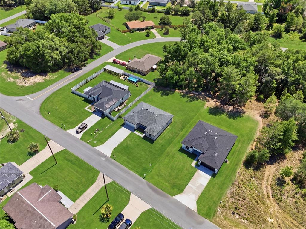 An aerial view shows several suburban houses with dark roofs and green lawns — 16843 SW 18TH AVENUE ROAD, OCALA, FL