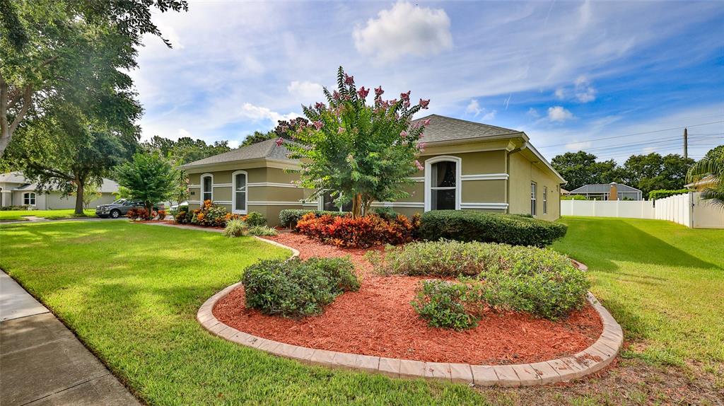 A single-story house with a green exterior, a landscaped front yard, and a paved walkway — 4269 MAYFAIR LANE, PORT ORANGE, FL