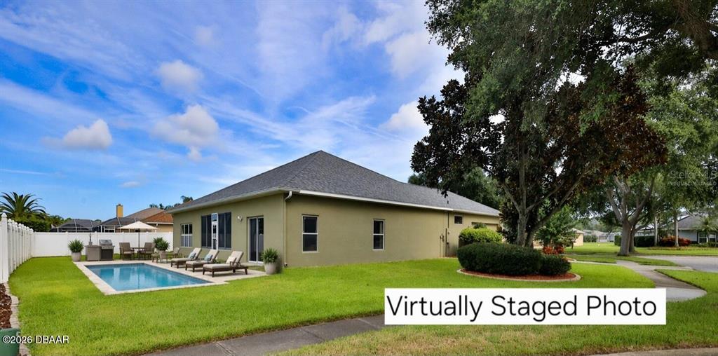 The exterior of a house features a swimming pool, a lawn, and large trees — 4269 MAYFAIR LANE, PORT ORANGE, FL