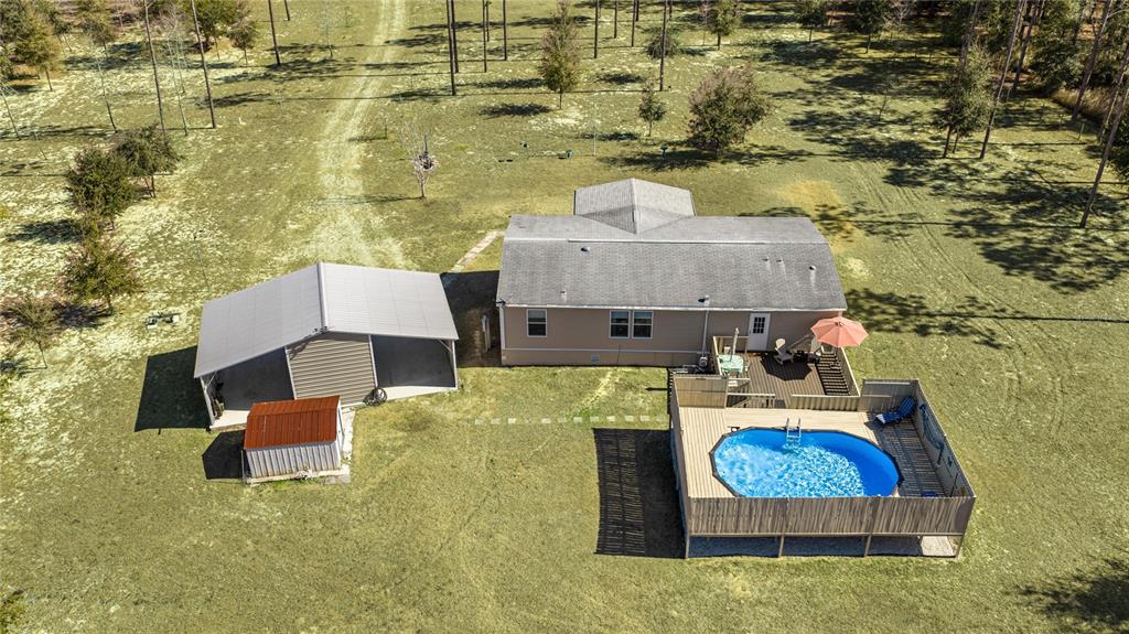 An aerial view shows a house with a carport, a shed, and an above-ground pool — 5130 SE 137TH AVENUE, MORRISTON, FL