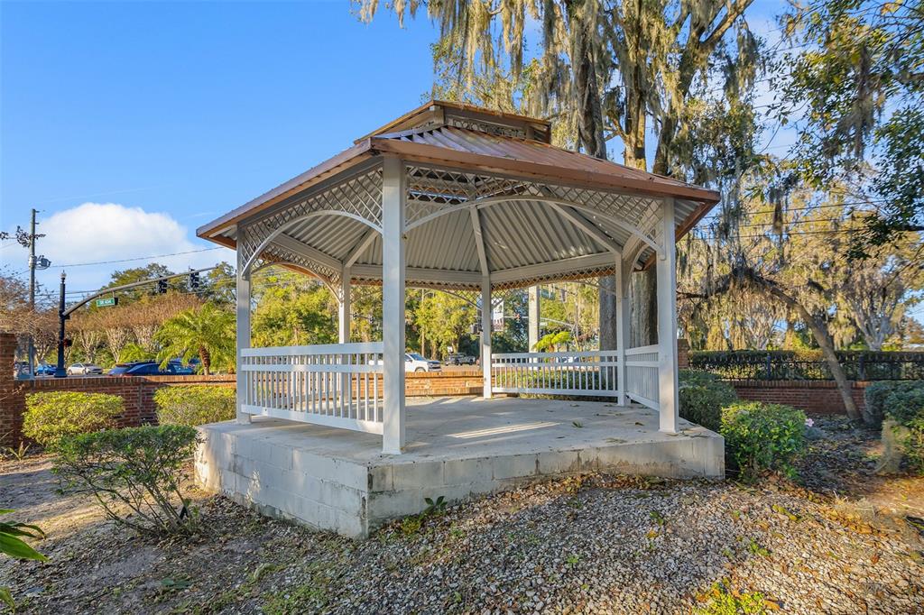 A white gazebo with a metal roof sits on a concrete base in a yard — 116 PHILADELPHIA WAY, WINTER SPRINGS, FL