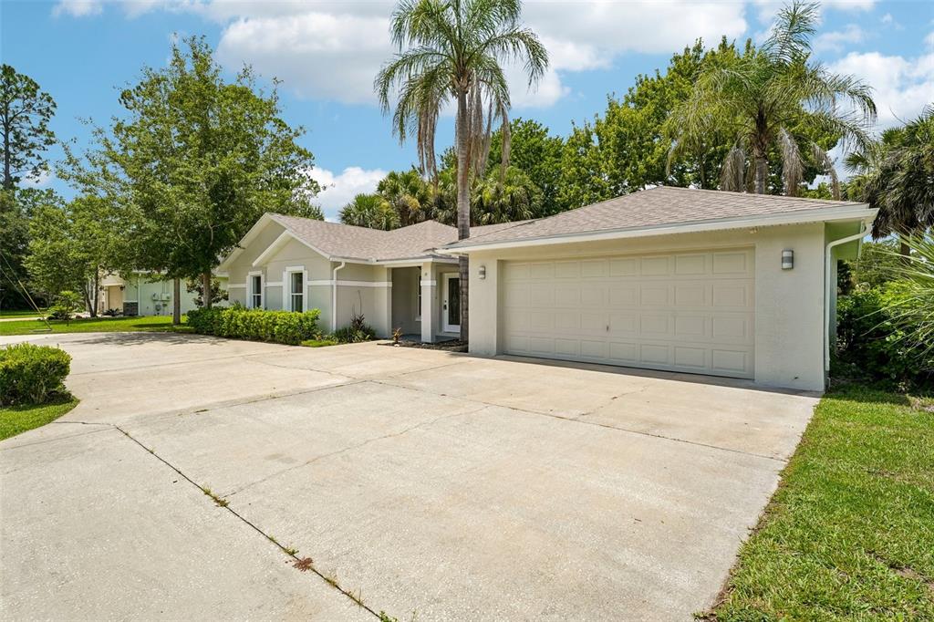 A single-story house with a beige exterior, a two-car garage, and a concrete driveway — 19 EMERSON DRIVE, PALM COAST, FL