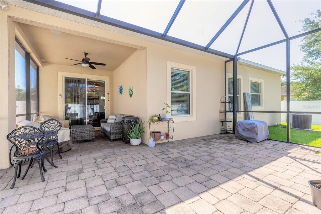 A covered patio with paver flooring, outdoor furniture, and a screened-in enclosure — 3968 SUNSET COVE DRIVE, PORT ORANGE, FL