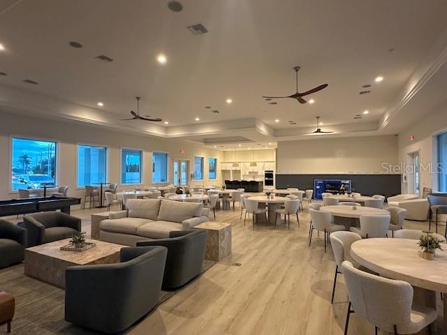 A spacious community clubhouse features light wood flooring, modern furniture, and multiple seating areas — 9001 GASPARILLA ROAD UNIT 42, PLACIDA, FL