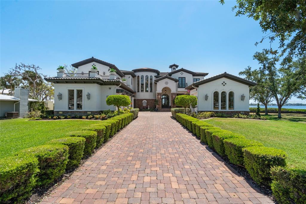 A multi-story stone house with a swimming pool and patio overlooking a sunset water view — 2107 4TH STREET COURT W, PALMETTO, FL