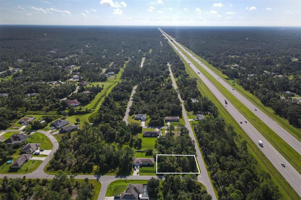 An aerial view shows a rectangular vacant lot highlighted in white within a wooded neighborhood — Lot # 19 RENTSCHER AVENUE, NORTH PORT, FL