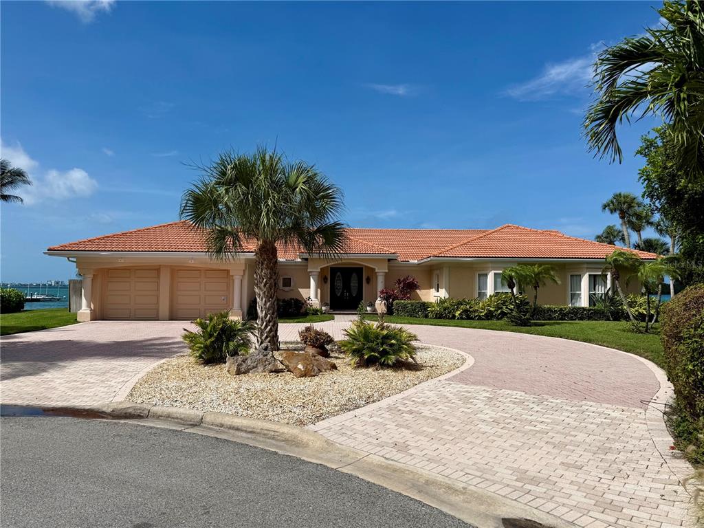 A single-story house with a terracotta tile roof and a circular paver driveway — 376 W ROYAL FLAMINGO DRIVE, SARASOTA, FL