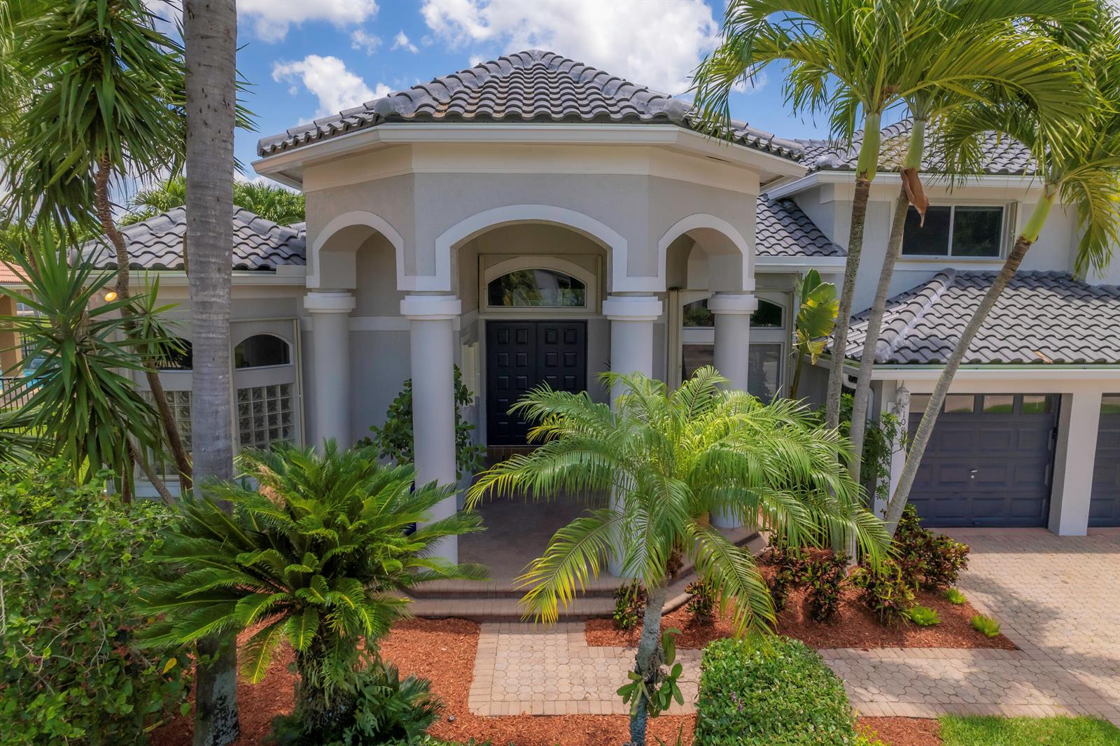 A two-story house with a tiled roof, arched entryway, and palm trees in the front yard — 10849 Bal Harbor Drive, Boca Raton FL 33498, BOCA RATON, FL