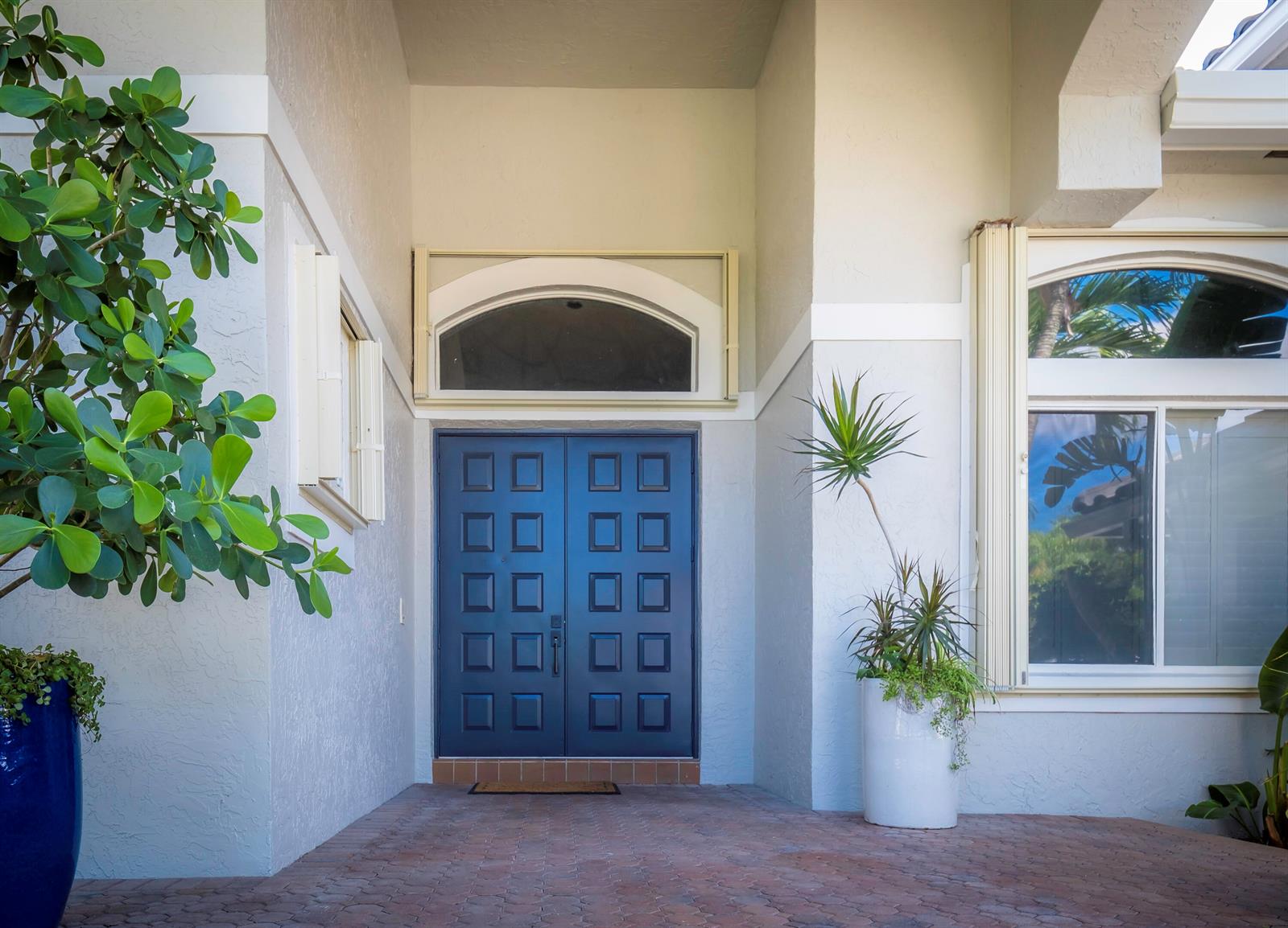 A front entryway features a dark blue double door, a transom window, and potted plants — 10849 Bal Harbor Drive, Boca Raton FL 33498, BOCA RATON, FL