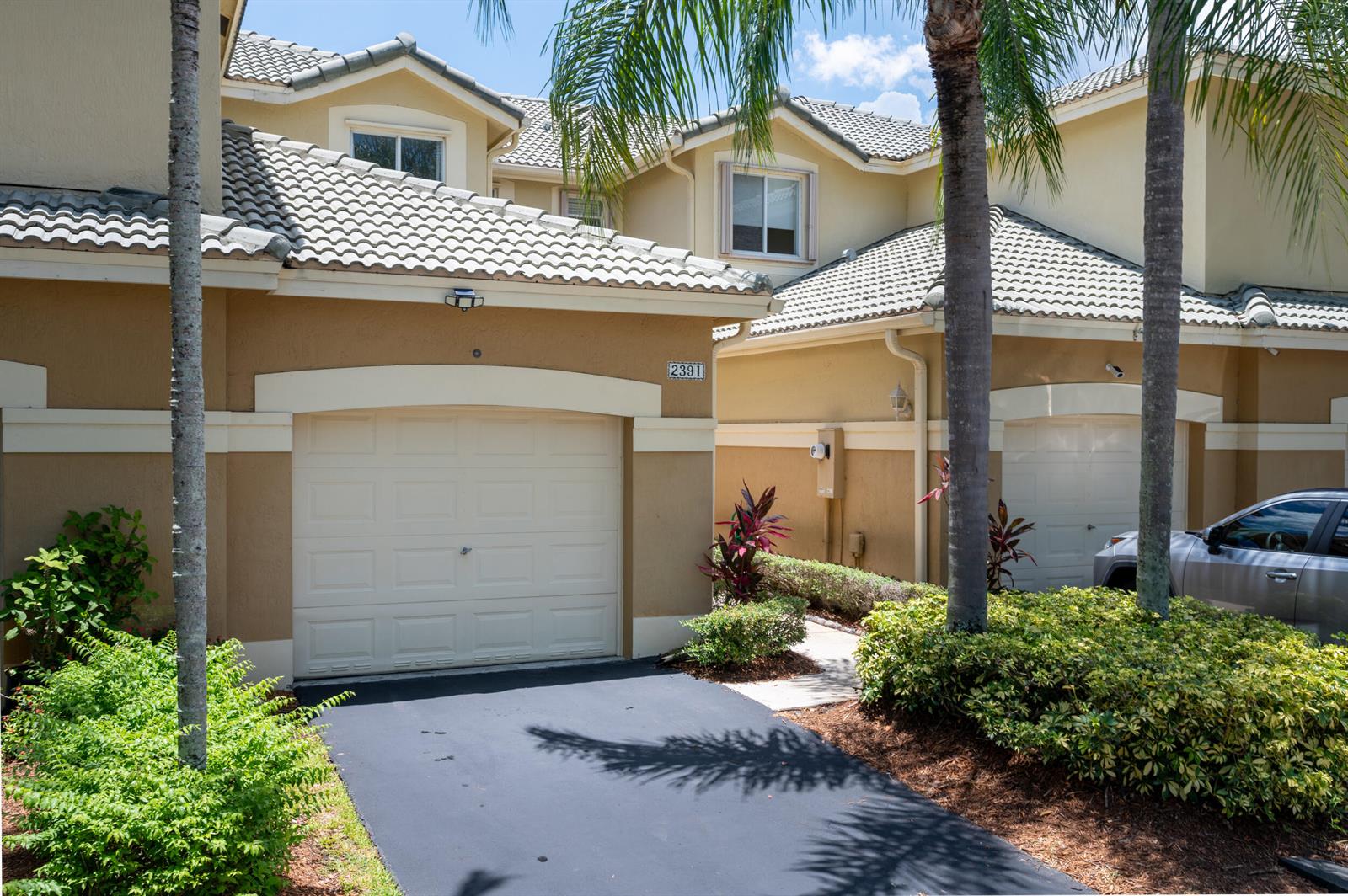 The exterior view shows two attached townhomes with beige stucco walls, tiled roofs, and garages — 2391 Pasadena Way, Weston FL 33327, WESTON, FL