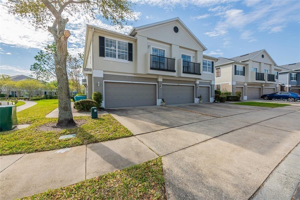 A two-story townhouse exterior features a beige facade, two garage doors, and small upper balconies — 6612 S GOLDENROD ROAD UNIT 104A, ORLANDO, FL