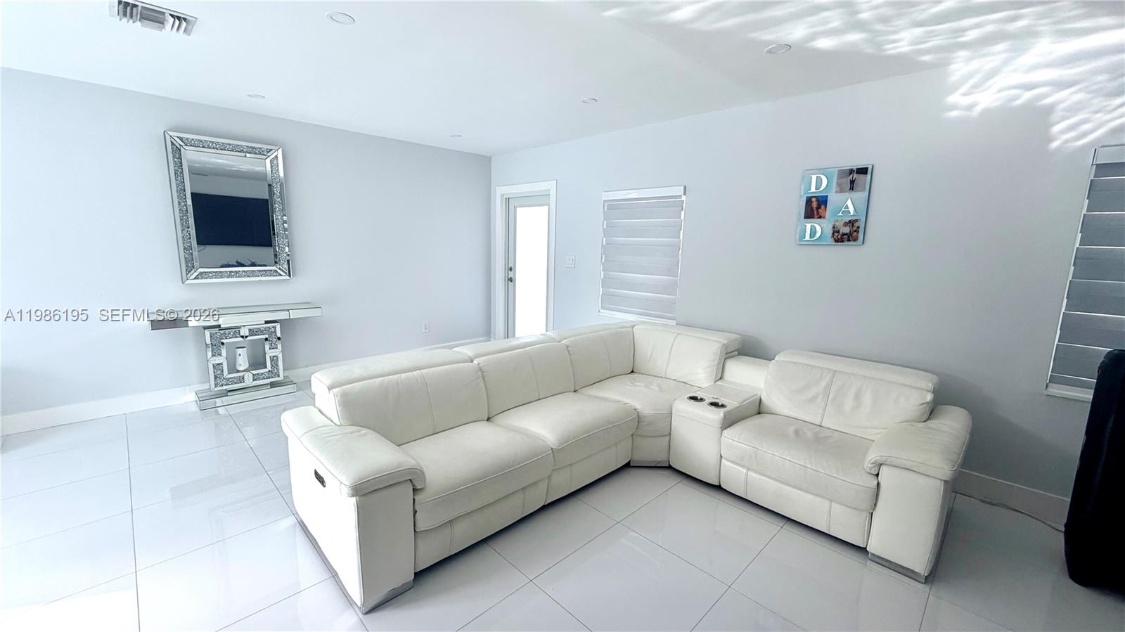 A living room features a white sectional sofa, tiled floors, and a mirrored console table — 14401 Boggs Dr, Miami FL 33176, MIAMI, FL