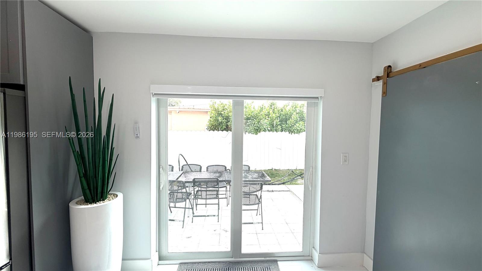 A sliding glass door leads to a patio with outdoor furniture in this room — 14401 Boggs Dr, Miami FL 33176, MIAMI, FL