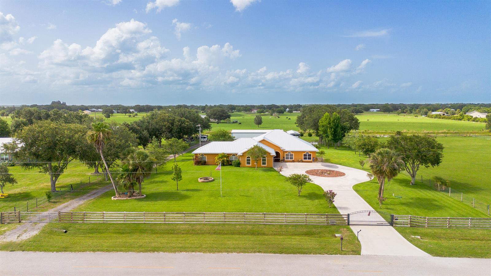 An aerial view shows a yellow house with a white roof on a grassy lot — 7611 SW 21st Parkway, Okeechobee FL 34974, OKEECHOBEE, FL