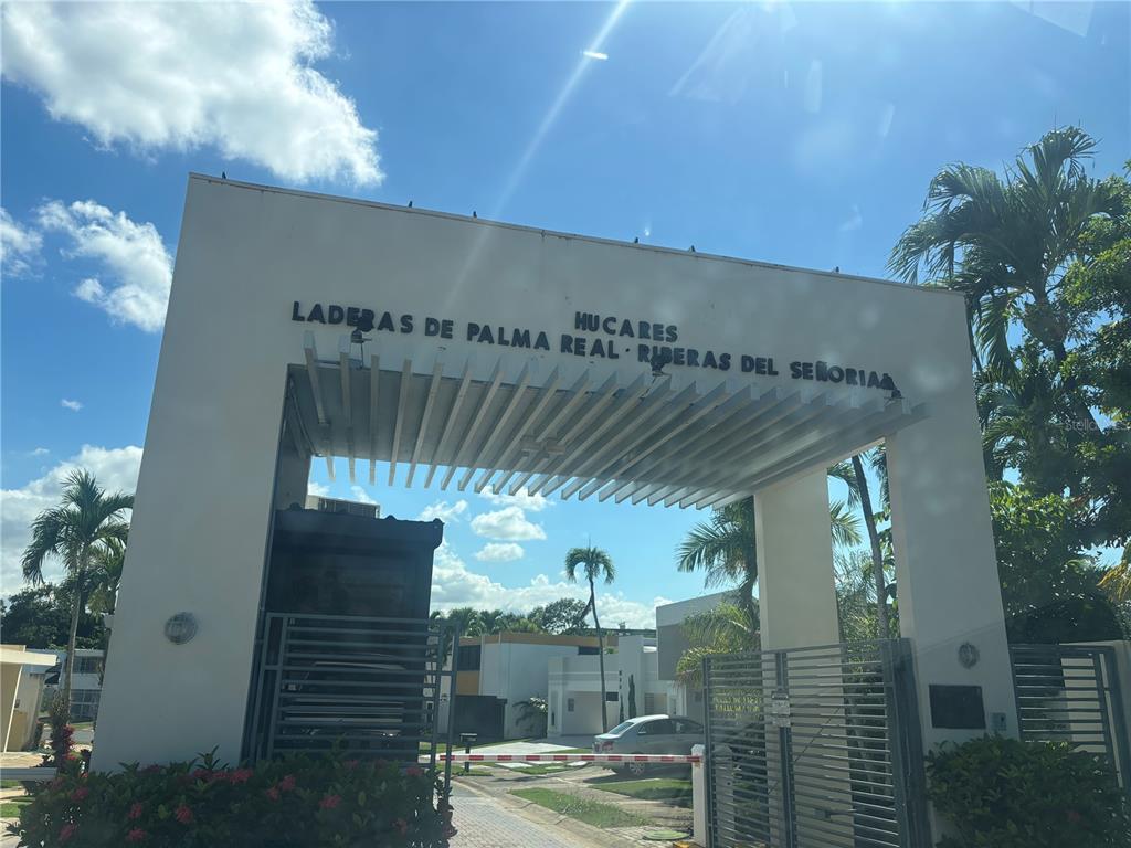 The entrance gate to a residential community features white pillars and a slatted overhead structure — W 4-14 CALDERÓN DE LA BARCA, SAN JUAN, PR