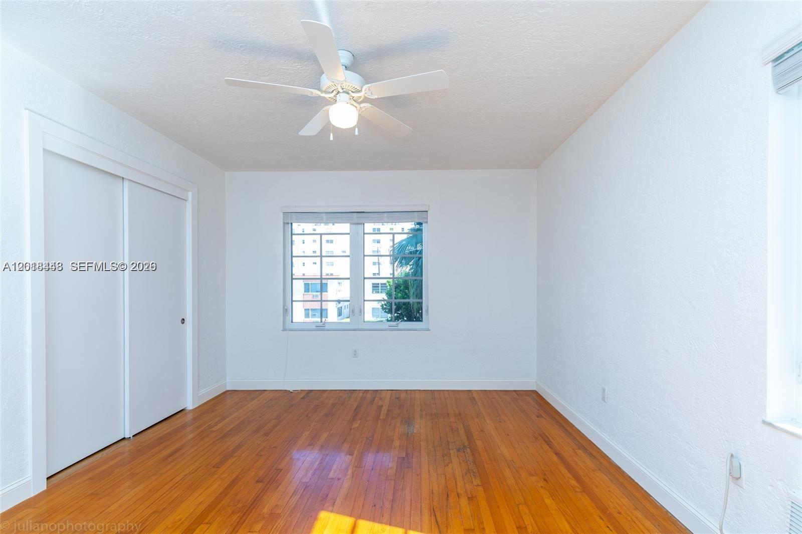 An empty bedroom features white walls, hardwood floors, a ceiling fan, and a sliding closet — 732 Euclid Ave # 6, Miami Beach FL 33139, MIAMI BEACH, FL