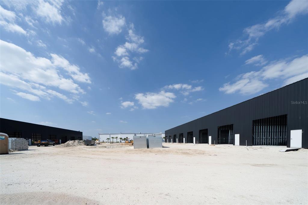 An exterior view of two modern, black industrial warehouse buildings under a blue sky — 8411-8419 DUFFIE DRIVE, PUNTA GORDA, FL