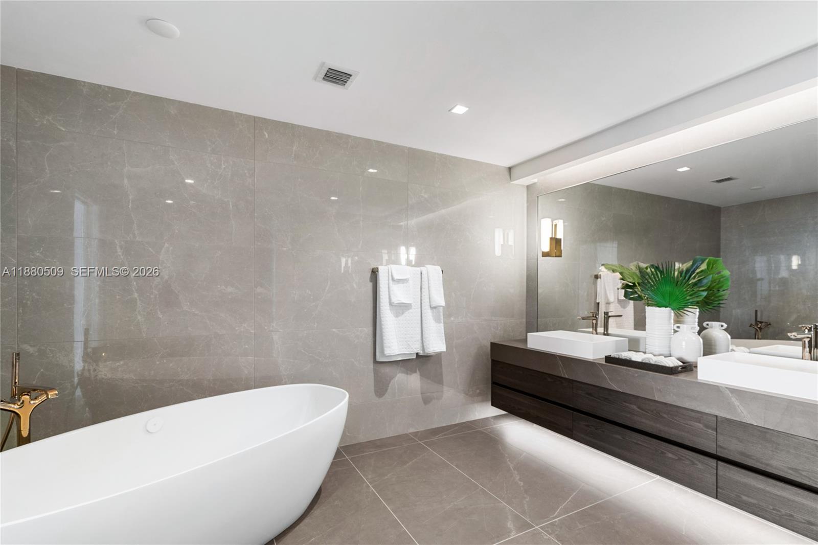 A modern bathroom features a freestanding tub, double vanity, and large-format gray marble wall tiles — 1116 N Ocean Blvd # 1404, Pompano Beach FL 33062, POMPANO BEACH, FL