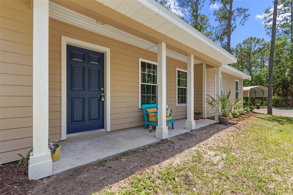 A tan house with a blue front door and a covered porch with white columns — 3296 N OLD DIXIE HIGHWAY, BUNNELL, FL