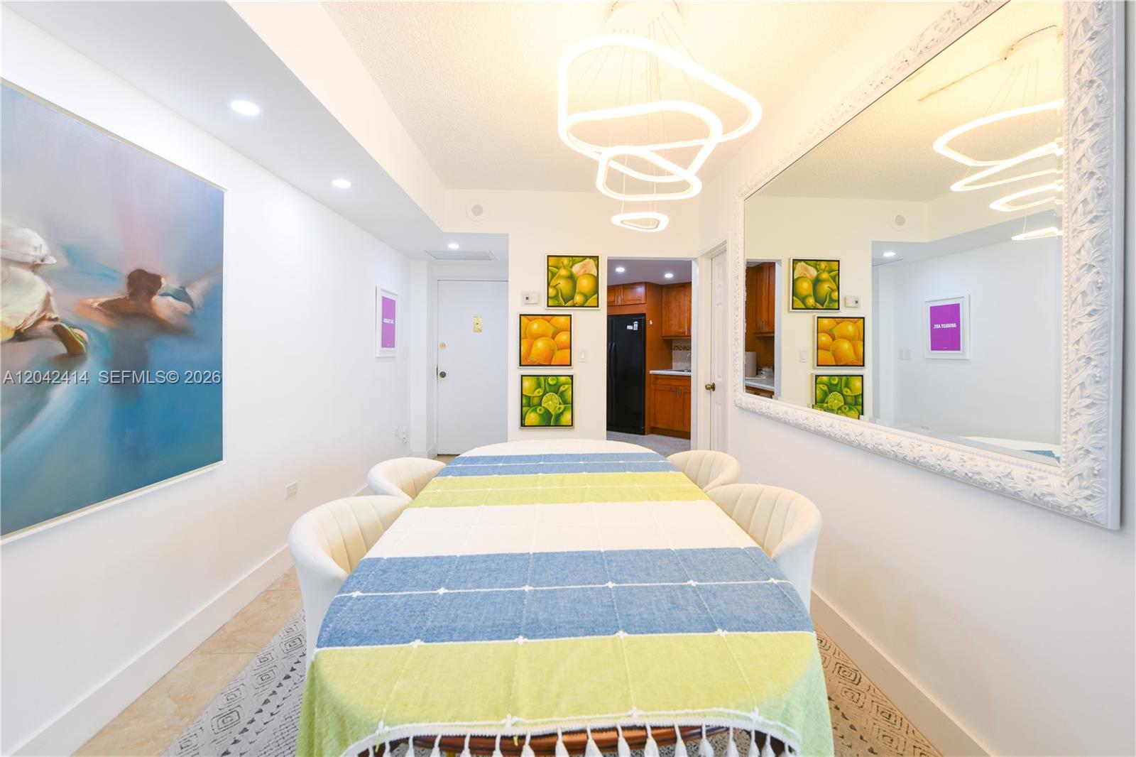 A dining room features a long table, modern light fixtures, a large mirror, and artwork — 801 Brickell Bay Dr # 1462, Miami FL 33131, MIAMI, FL