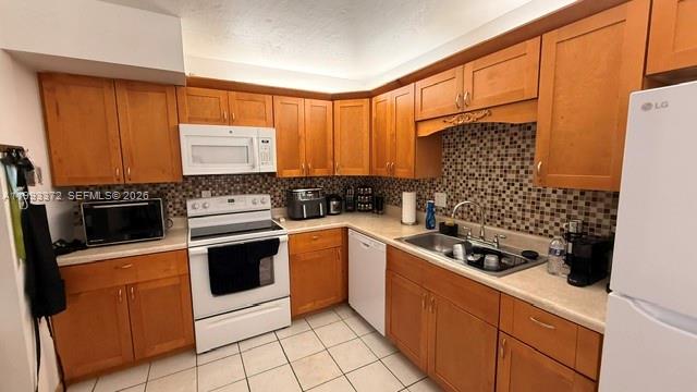 A kitchen with wood cabinets, light countertops, a white stove, and a tiled backsplash — 231 Lakeview Dr # 204, Weston FL 33326, WESTON, FL