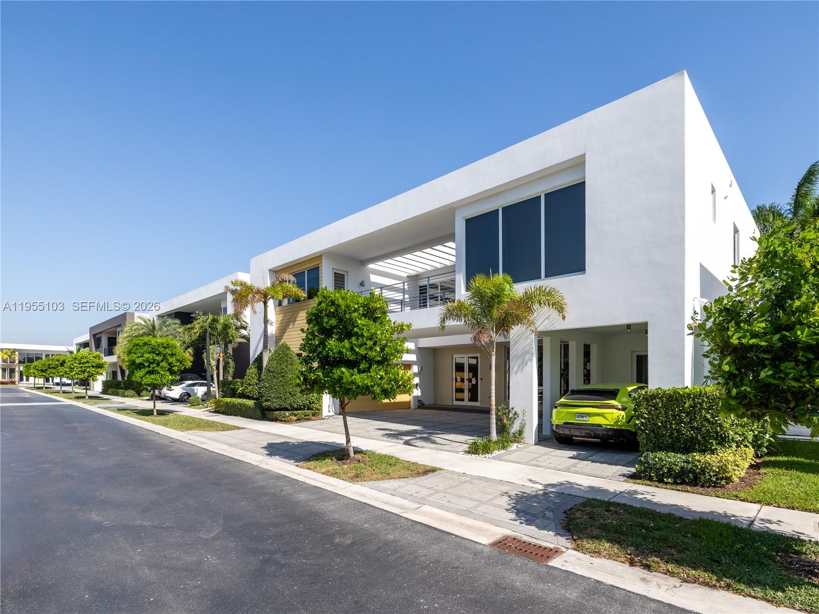 A modern two-story white house with a lime green car parked in the carport — 7451 NW 103rd Ct, Doral FL 33178, DORAL, FL