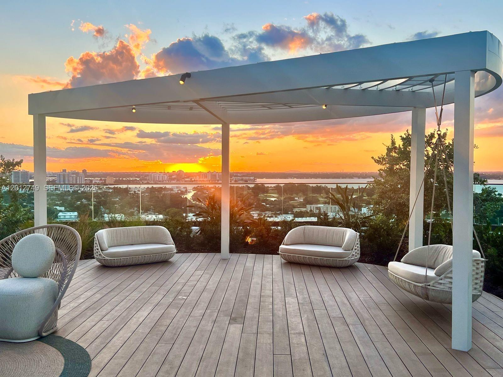 A rooftop deck features a white pergola, modern outdoor seating, and a sunset city view — 580 72nd St # 1111, Miami Beach FL 33141, MIAMI BEACH, FL