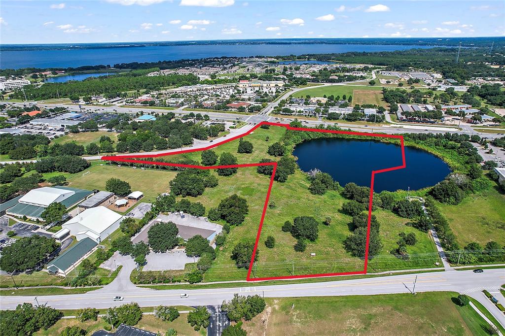 An aerial view shows a vacant lot with a pond outlined in red — DAVID WALKER & US HWY 441 DRIVE, TAVARES, FL