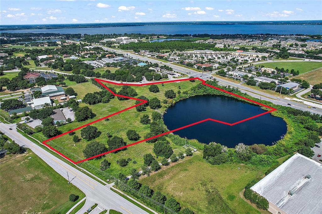 An aerial view shows a vacant lot with a pond outlined in red — DAVID WALKER & US HWY 441 DRIVE, TAVARES, FL