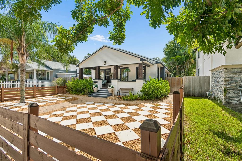 A backyard patio with a pergola, outdoor seating, and string lights at sunset — 1011 14TH STREET N, ST PETERSBURG, FL