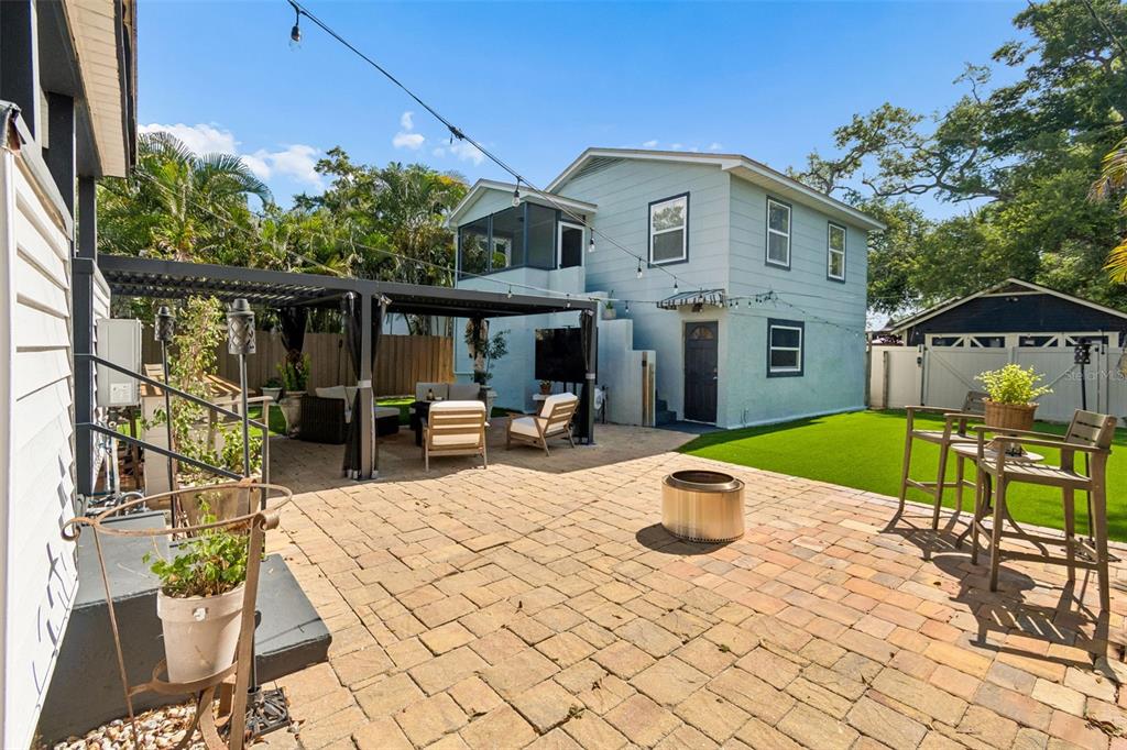 A living room features a white brick fireplace, wood ceiling beams, and an open kitchen — 1011 14TH STREET N, ST PETERSBURG, FL