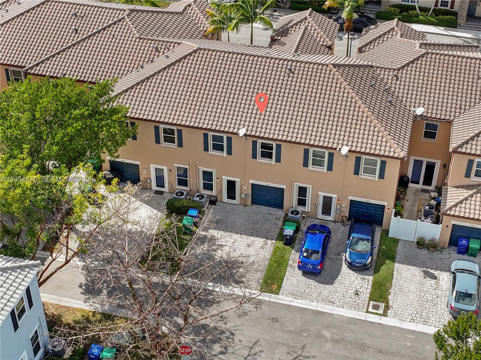 An aerial view shows a row of townhouses with tiled roofs and paved driveways — 16958 SW 92nd St # 16958, Miami FL 33196, MIAMI, FL
