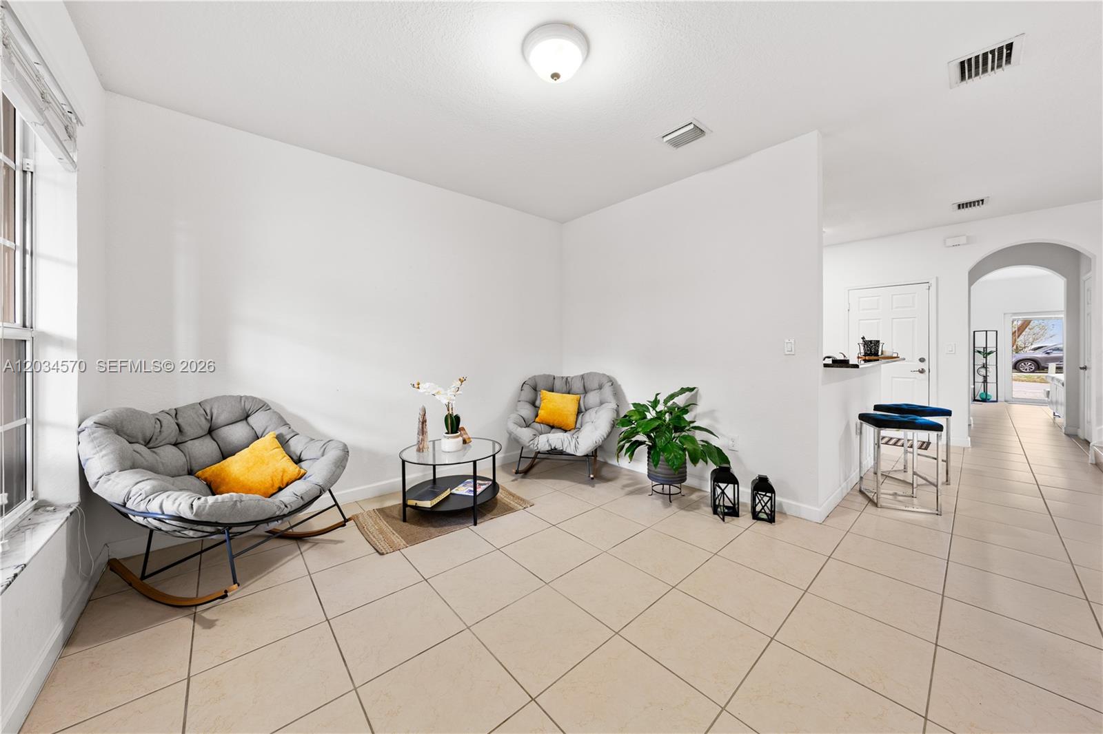 A living area features two grey rocking chairs, a glass coffee table, and tile flooring — 16958 SW 92nd St # 16958, Miami FL 33196, MIAMI, FL